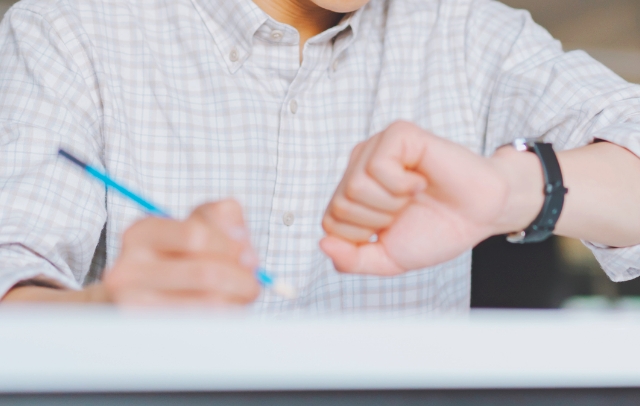 時間を気にしながら勉強する学生